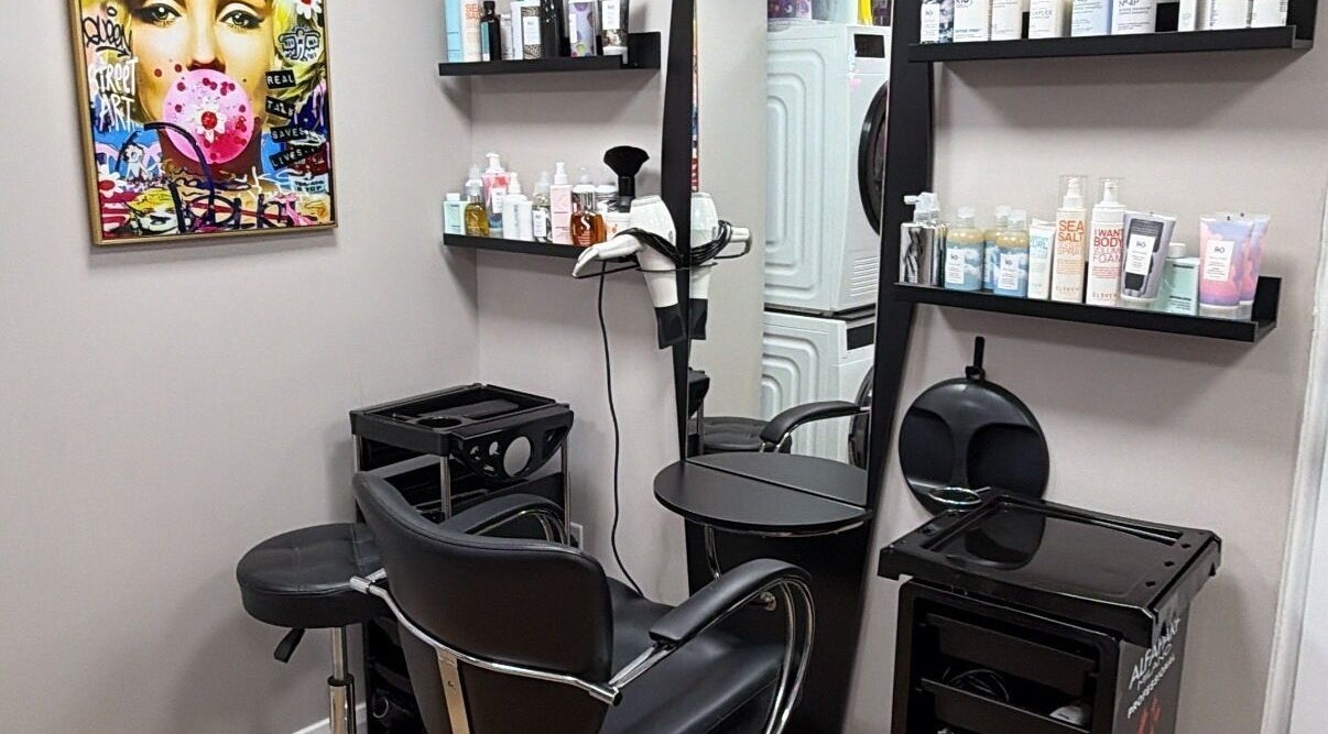 One2one salon in Dublin, County Dublin, IE features a stylish chair, shelves with products, and vibrant wall art.