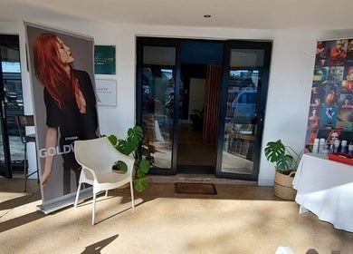 Therapy Hair Studio entrance in Howick, Kwazulu-natal, ZA showcasing stylish decor and beauty posters.