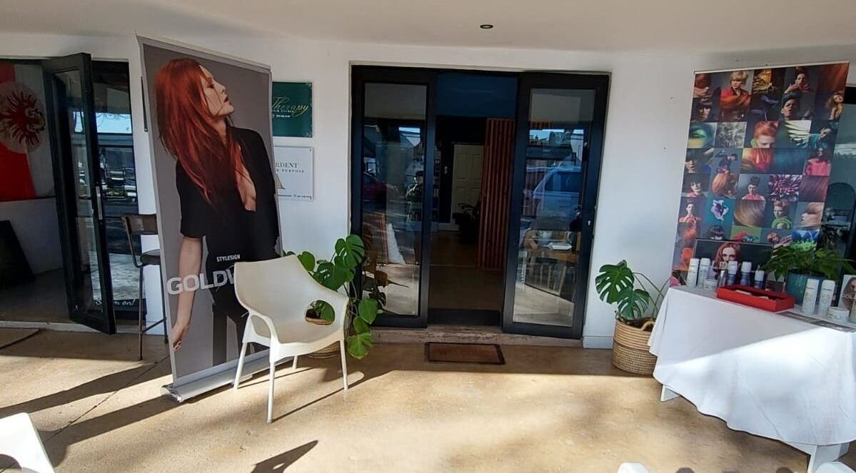 Therapy Hair Studio entrance in Howick, Kwazulu-natal, ZA showcasing stylish decor and beauty posters.