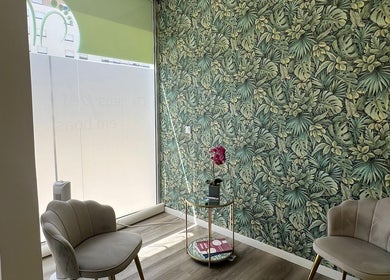 Sala de espera elegante no Centro Podológico de Lisboa, Lisboa, Lisboa, PT, com parede de folhagem tropical.