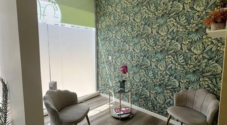Sala de espera elegante no Centro Podológico de Lisboa, Lisboa, Lisboa, PT, com parede de folhagem tropical.