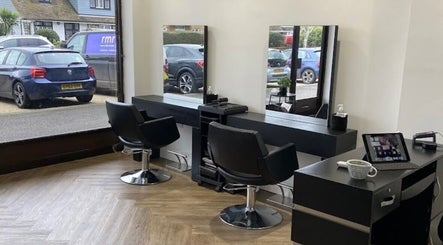 Libby’s Hair salon in Worthing, England, GB with modern black chairs and large mirrors.