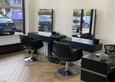 Modern interior of Libby’s Hair in Worthing, England, GB, featuring sleek styling chairs and mirrors.