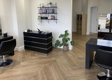 Modern interior of Libby’s Hair in Worthing, England, GB with stylish decor and warm lighting.