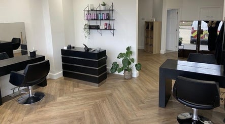 Modern interior of Libby’s Hair in Worthing, England, GB with stylish decor and warm lighting.