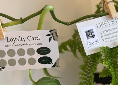 Libby’s Hair loyalty card and contacts in Worthing, England surrounded by greenery.