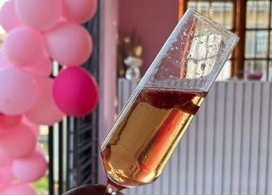 Champagne glass and pink balloons at KM Beauty Lounge, Randburg, Gauteng, ZA, embodying elegance and celebration.