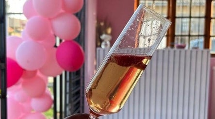 Champagne glass and pink balloons at KM Beauty Lounge, Randburg, Gauteng, ZA, embodying elegance and celebration.