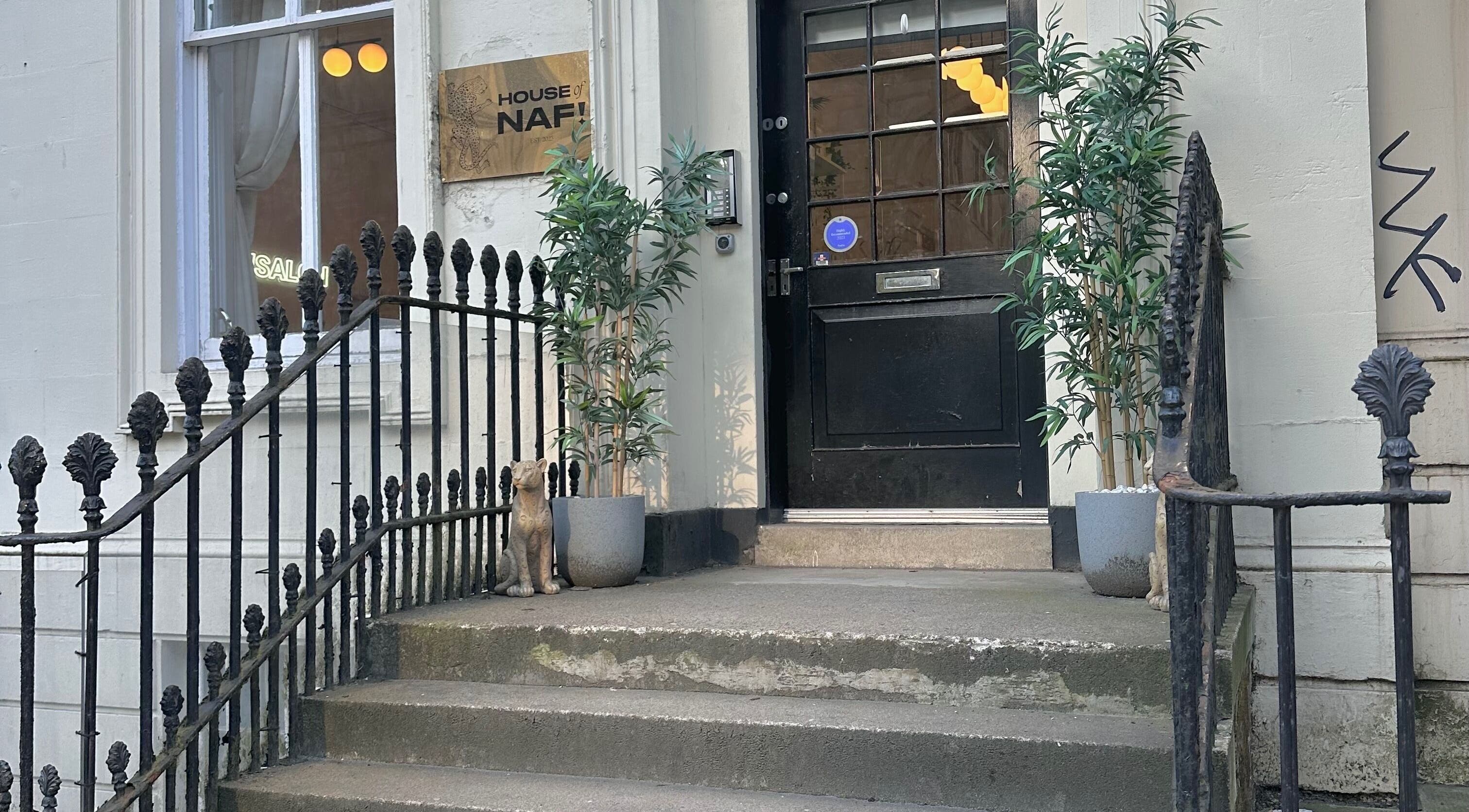 Elegant entry of LMS Nails in Glasgow, Scotland, GB showcasing stairs and potted plants.