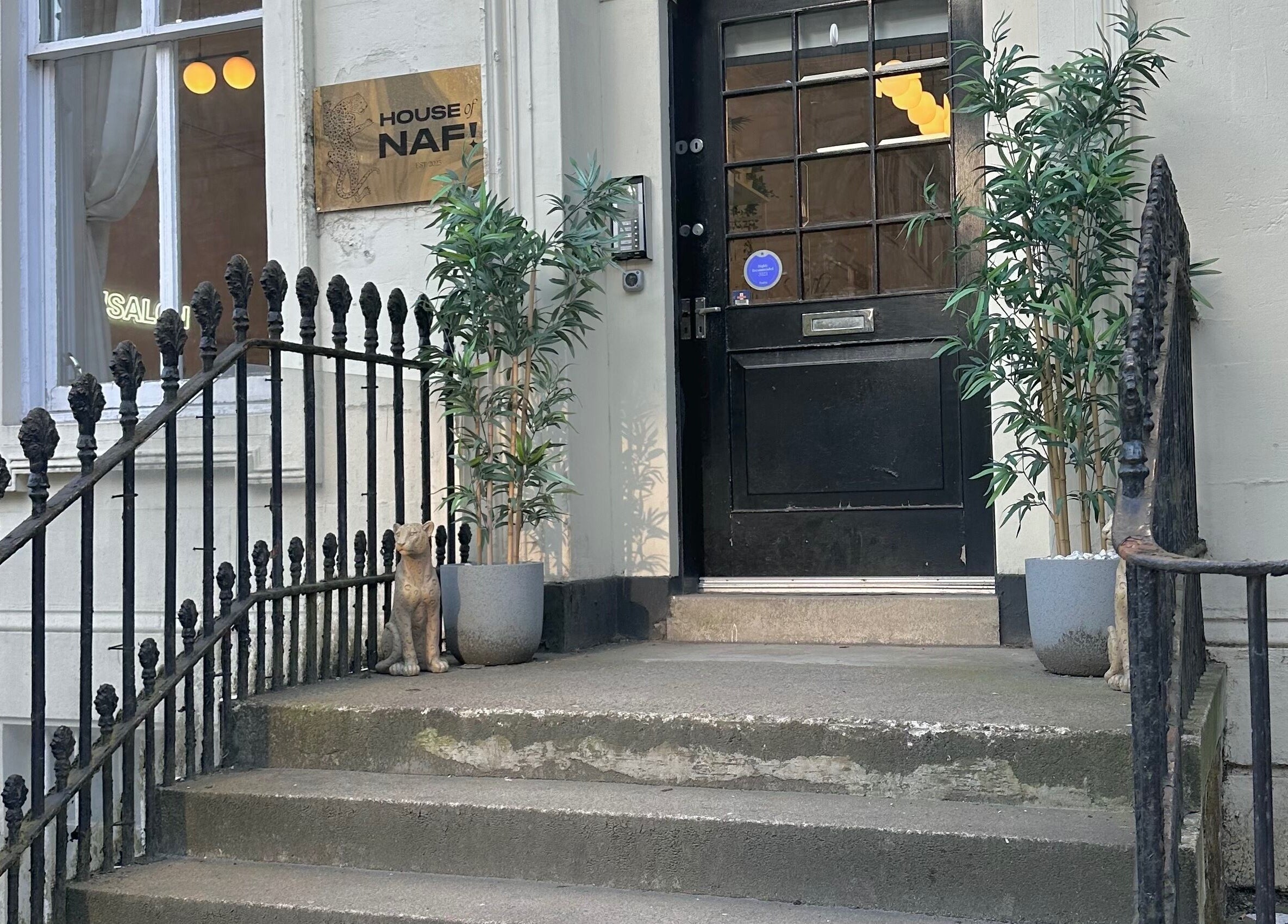 Elegant entrance at LMS Nails in Glasgow, Scotland, GB, with potted plants and a decorative cat.