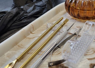 Gleaming nail tools neatly arranged on a marble tray at Boho Glow Nails, Launceston, England, GB.