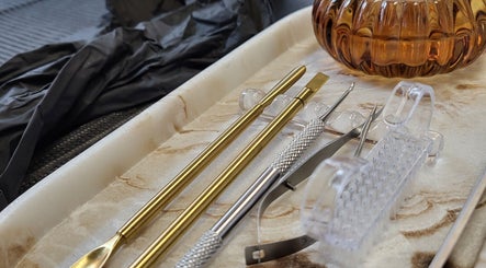 Gleaming nail tools neatly arranged on a marble tray at Boho Glow Nails, Launceston, England, GB.
