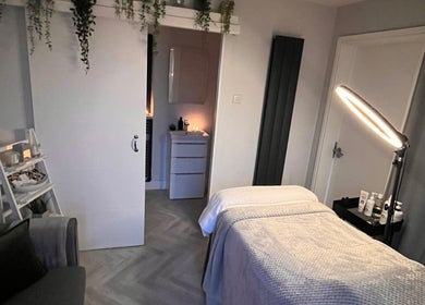 Relaxing treatment room at Rebecca Louise Beauty, Culcheth, England, GB, featuring a massage table and ambient lighting.