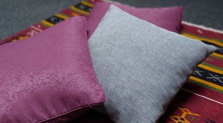 Cozy cushions on vibrant rug at City Zen Sanctuary, Edinburgh, Scotland, GB create a calming ambiance.