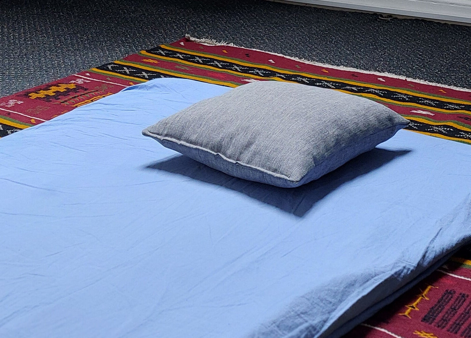 Relaxation mat setup at City Zen Sanctuary, Edinburgh, Scotland, GB, on a vibrant patterned rug.