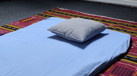 Relaxation mat setup at City Zen Sanctuary, Edinburgh, Scotland, GB, on a vibrant patterned rug.