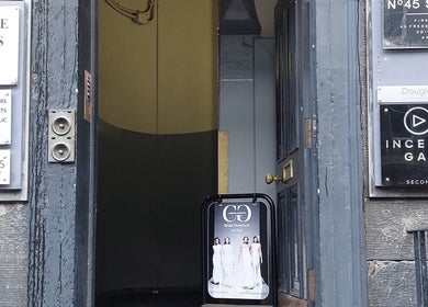 Entrance to City Zen Sanctuary in Edinburgh, Scotland, featuring various business signs.