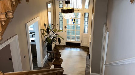 Chic entrance hall at Croftpark House Spa, Airdrie, Scotland, GB with a stained-glass door and chandelier.