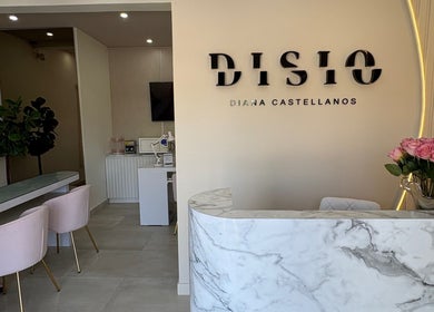 Recepción moderna de Disio Nails en Chihuahua, Chihuahua, MX, con diseño de mármol y sillas rosas.
