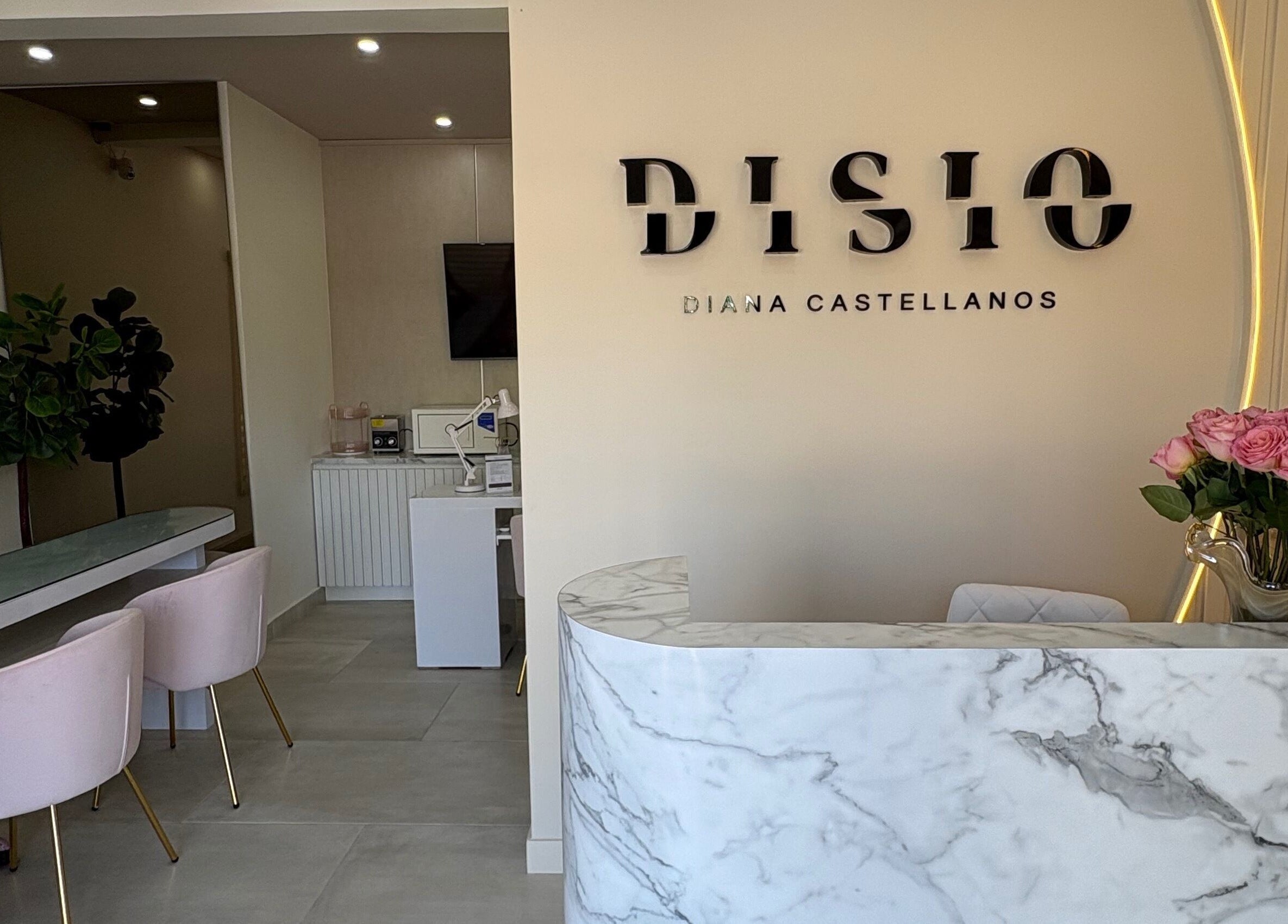 Recepción moderna de Disio Nails en Chihuahua, Chihuahua, MX, con diseño de mármol y sillas rosas.