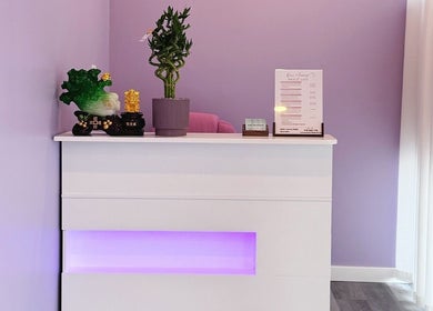 OMI MASSAGE reception desk in Lawrenceville, Georgia, US with purple accents and elegant decor.