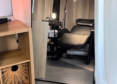 Elegant treatment room at Ink & Lam, London, England, featuring a plush black chair and modern decor.