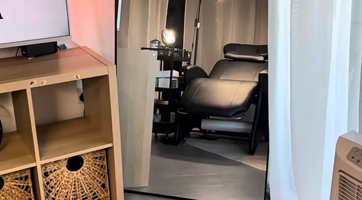 Elegant treatment room at Ink & Lam, London, England, featuring a plush black chair and modern decor.