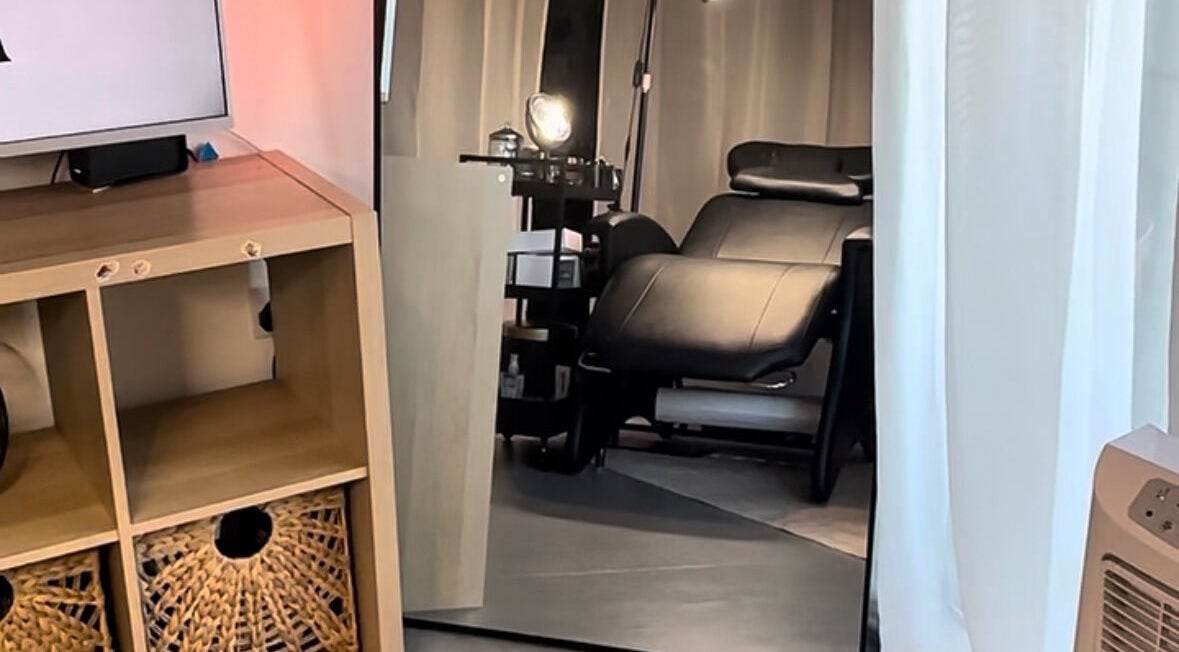 Elegant treatment room at Ink & Lam, London, England, featuring a plush black chair and modern decor.