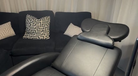 Luxurious black salon chair and couch with modern pillows at Ink & Lam, London, England, GB.
