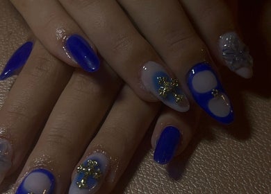 Manucure élégante avec des ongles bleus et motifs dorés chez Nails.lou à Faucompierre, Grand Est, FR.