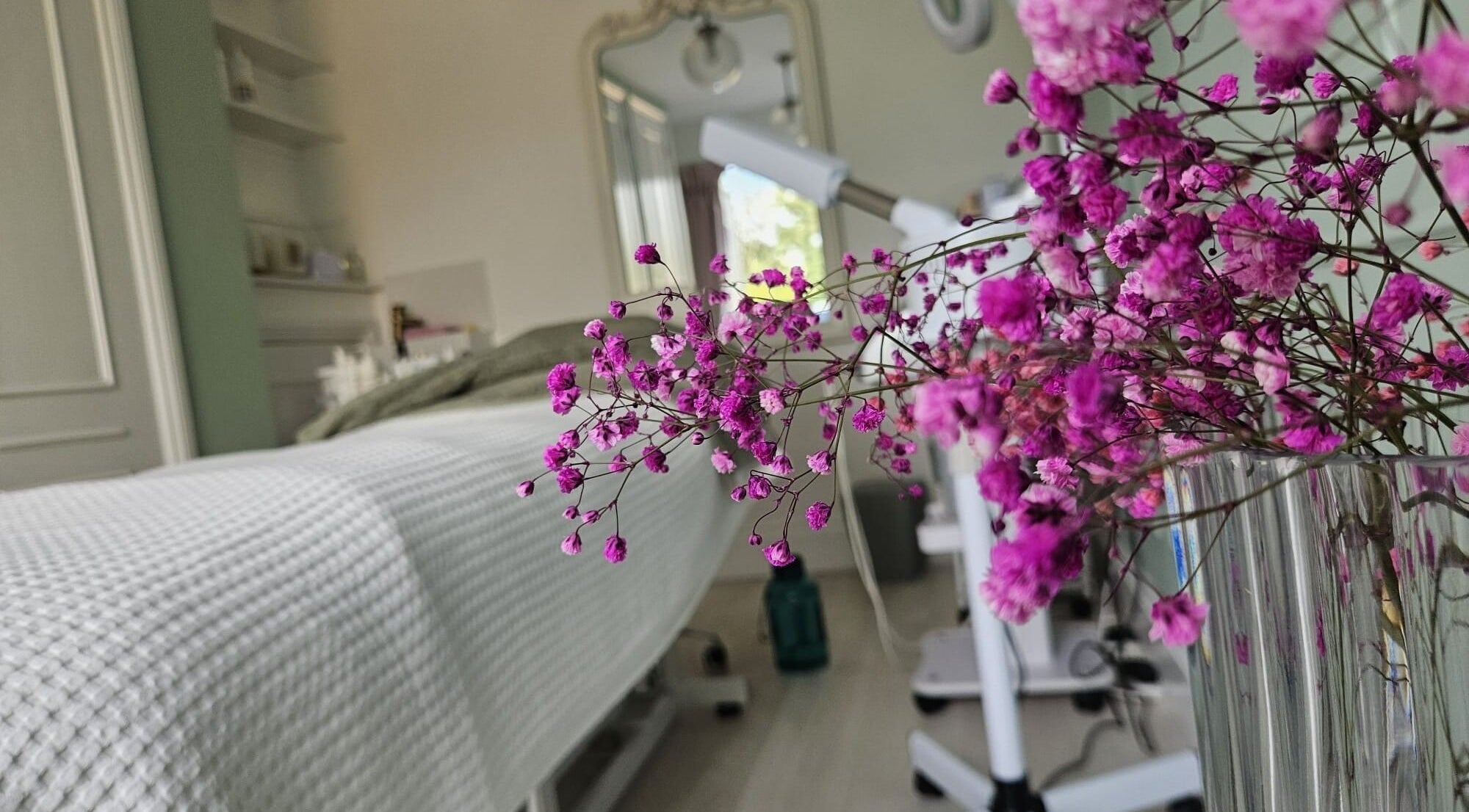 Tranquil treatment room at Skinology with pink flowers in Shenley Lodge, England, GB.