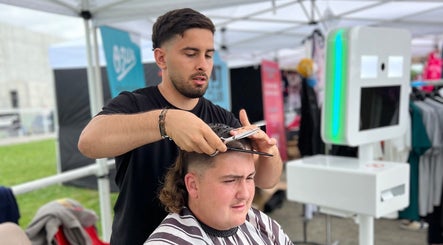 Coiffeur stylisant un client à Chez Dam’s, Garidech, Occitanie, FR sous tente moderne.