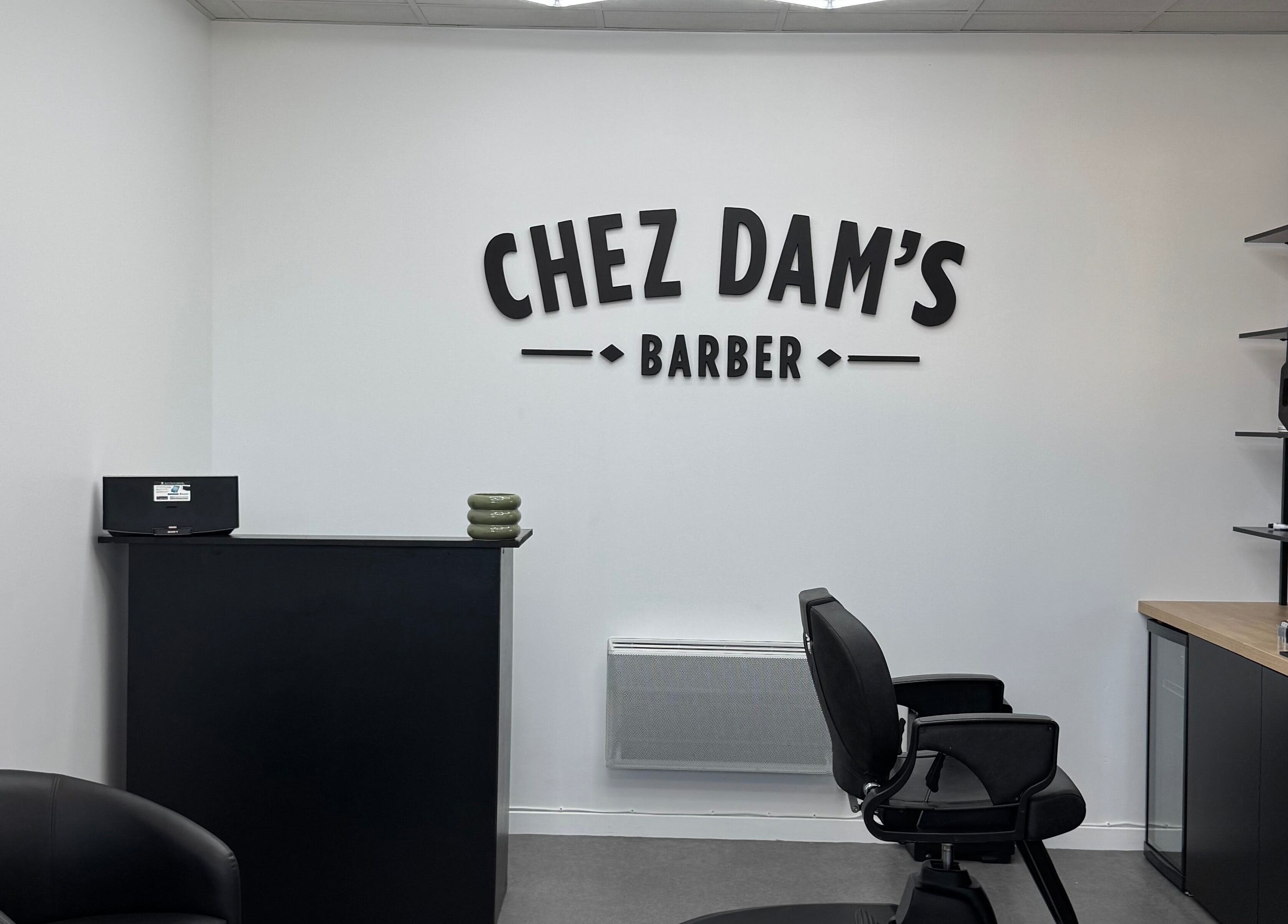 Intérieur moderne de Chez Dam’s à Pechbonnieu, Occitanie, FR, avec fauteuil et décor élégant.