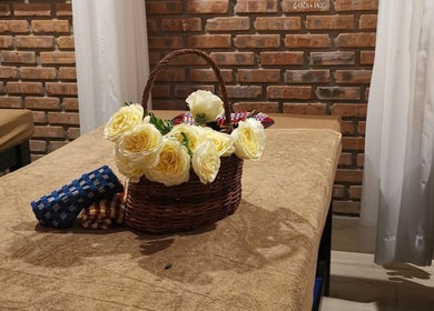 Giỏ hoa hồng vàng tươi trên bàn massage tại Ola spa, Đà Nẵng, Đà Nẵng, VN, tạo không gian thư giãn.