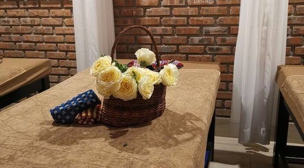 Giỏ hoa hồng vàng tươi trên bàn massage tại Ola spa, Đà Nẵng, Đà Nẵng, VN, tạo không gian thư giãn.