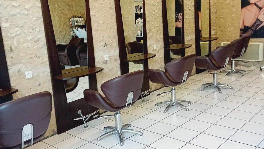 Intérieur moderne de Severine Coiffure à Saint-séverin, Nouvelle-Aquitaine, FR avec fauteuils chics.