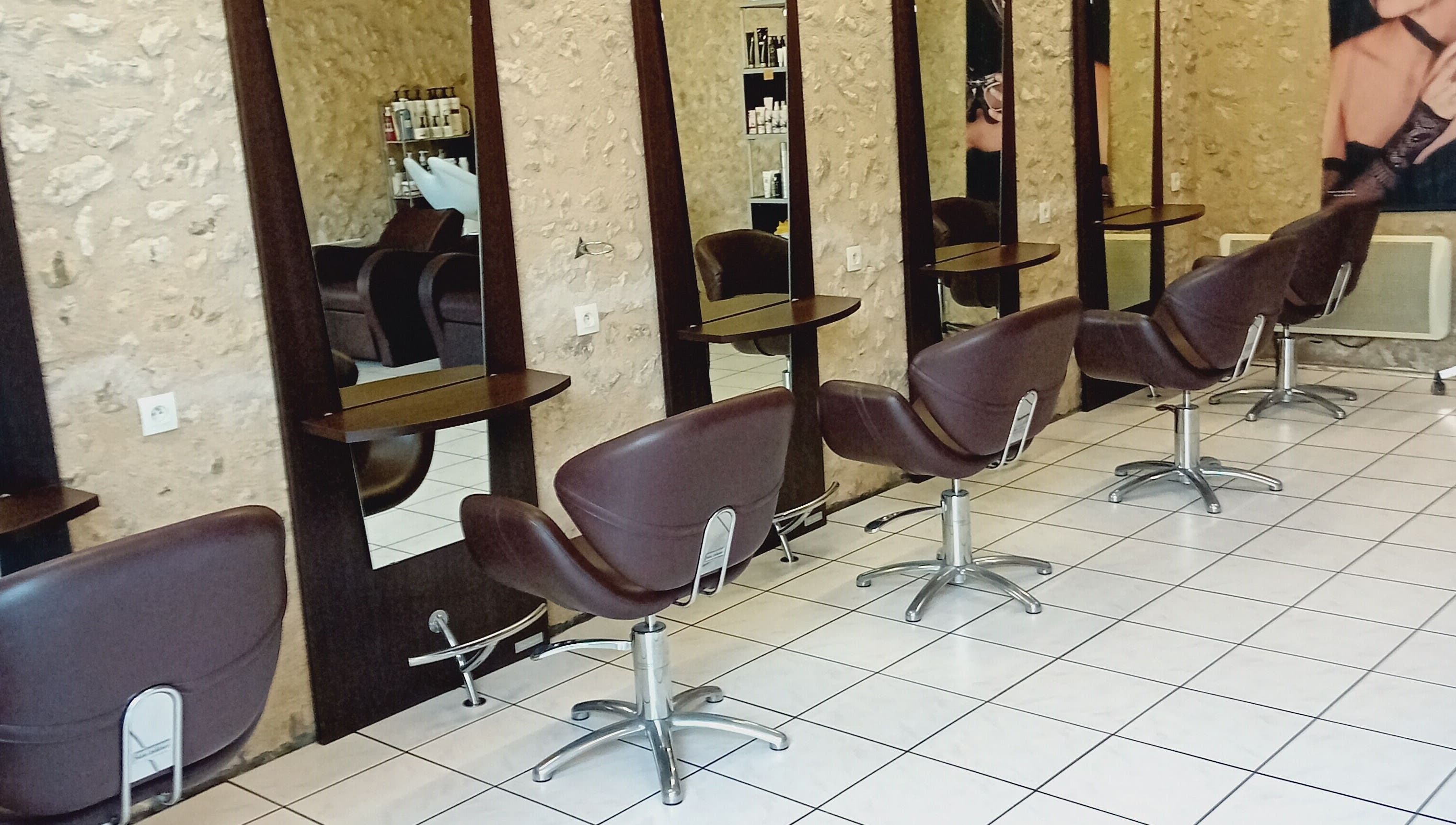 Intérieur moderne de Severine Coiffure à Saint-séverin, Nouvelle-Aquitaine, FR avec fauteuils chics.