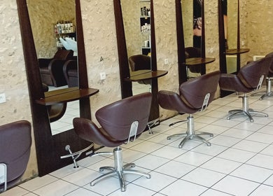 Intérieur moderne de Severine Coiffure à Saint-séverin, Nouvelle-Aquitaine, FR avec fauteuils chics.