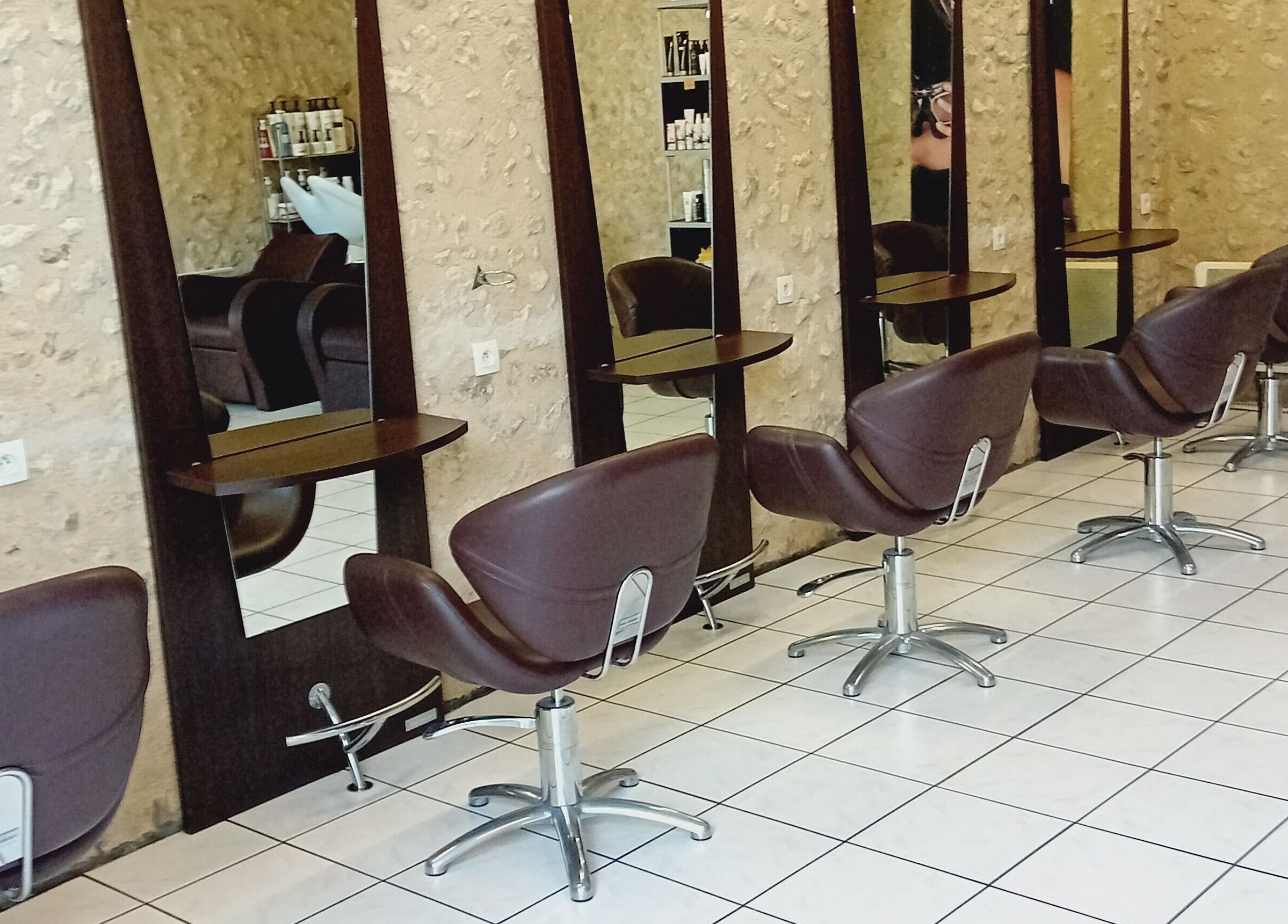 Intérieur moderne de Severine Coiffure à Saint-séverin, Nouvelle-Aquitaine, FR avec fauteuils chics.