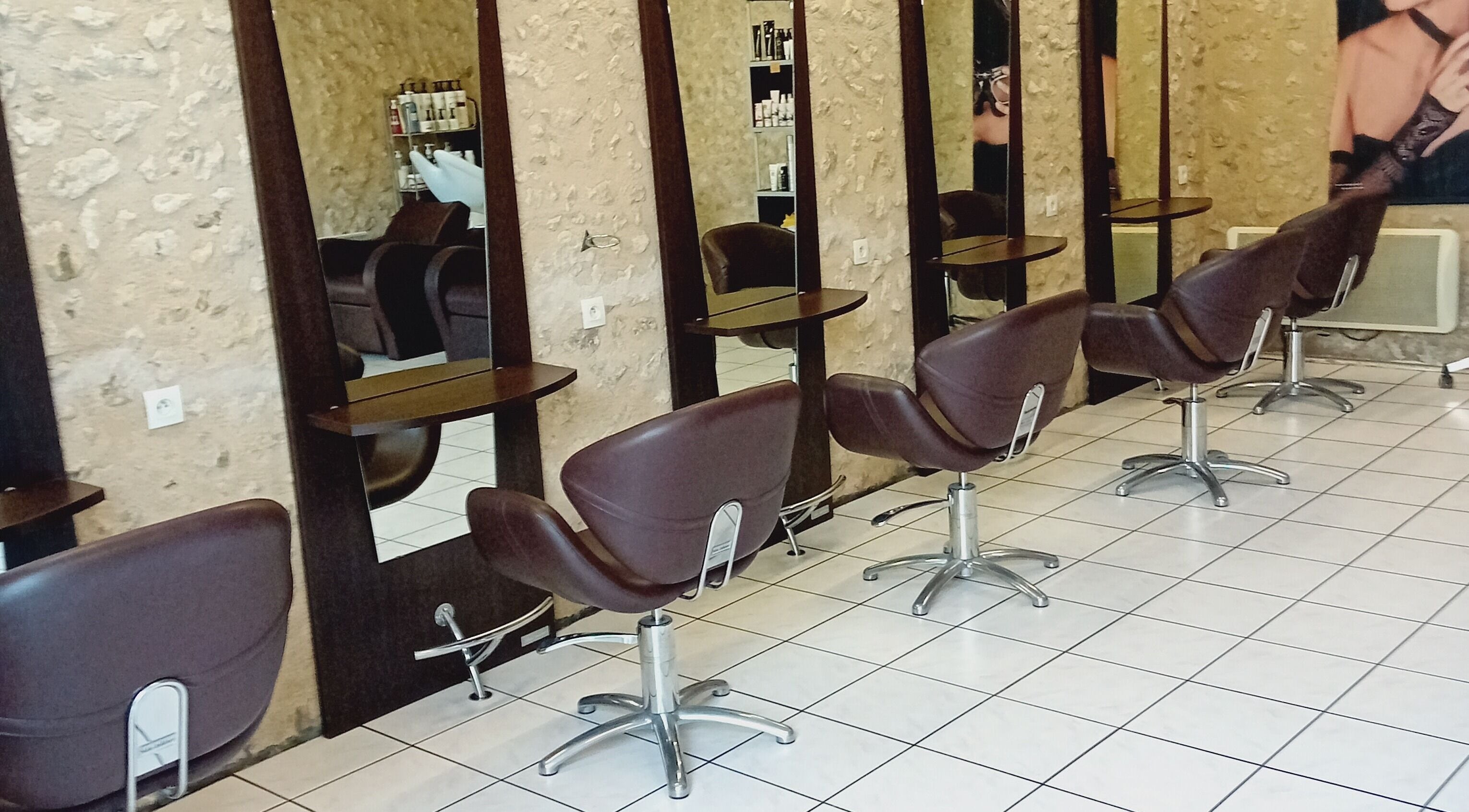 Intérieur moderne de Severine Coiffure à Saint-séverin, Nouvelle-Aquitaine, FR avec fauteuils chics.