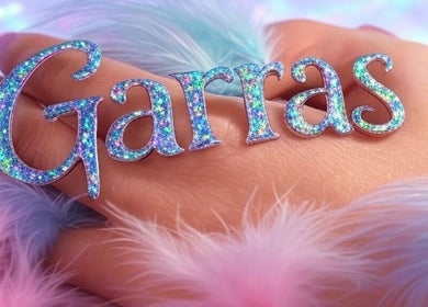 Mano decorada con letras brillantes en Garras Creative Nails by Pily García, Madras, Oregon, US.