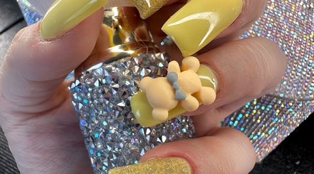 Uñas amarillas con diseño de osito en Garras Creative Nails by Pily García, Madras, Oregon, US.