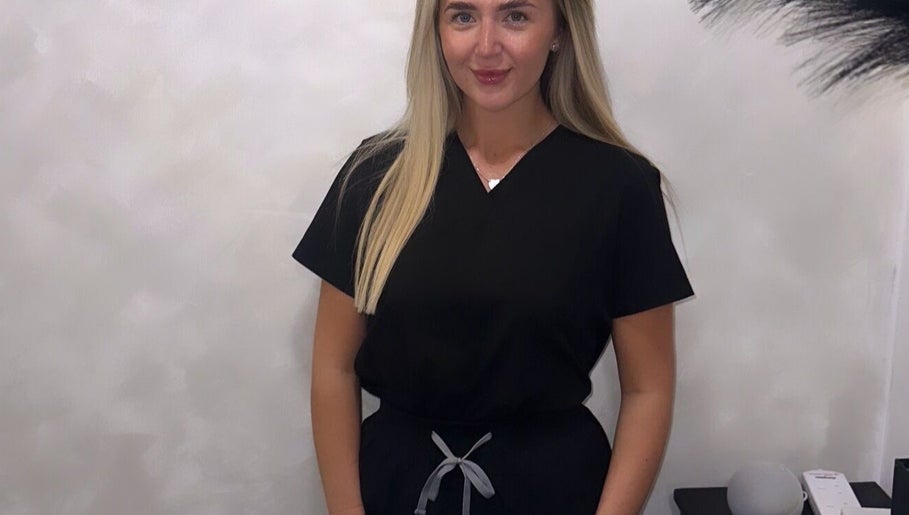 Professional at Blushed By Soph in Runcorn, England, GB, wearing a sleek, black uniform in a serene setting.