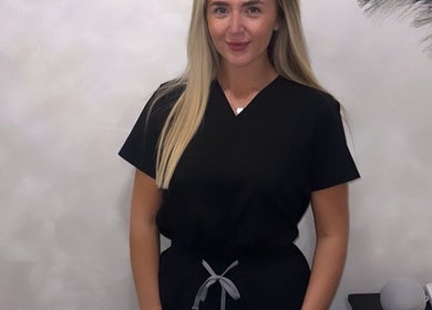 Professional at Blushed By Soph in Runcorn, England, GB, wearing a sleek, black uniform in a serene setting.