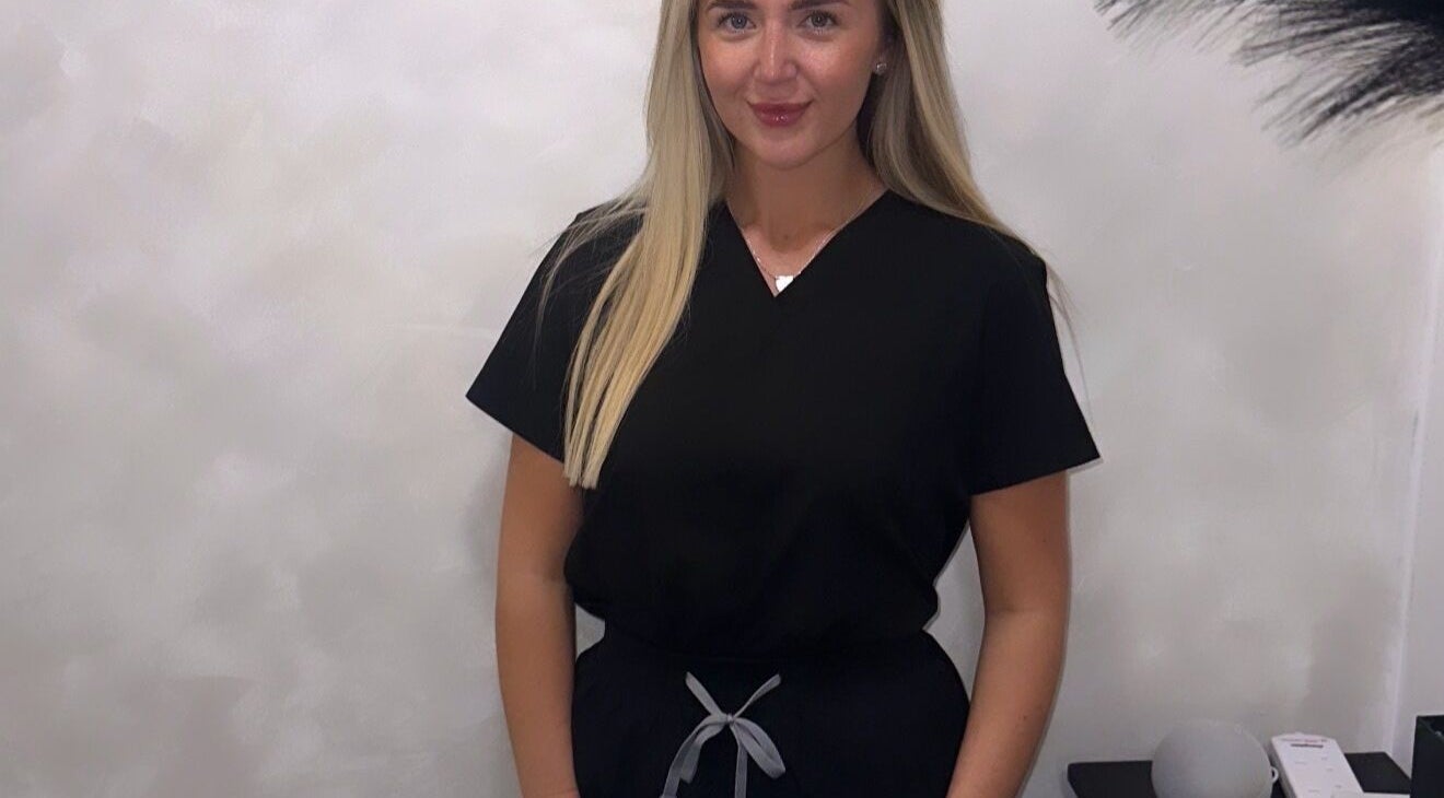 Professional at Blushed By Soph in Runcorn, England, GB, wearing a sleek, black uniform in a serene setting.