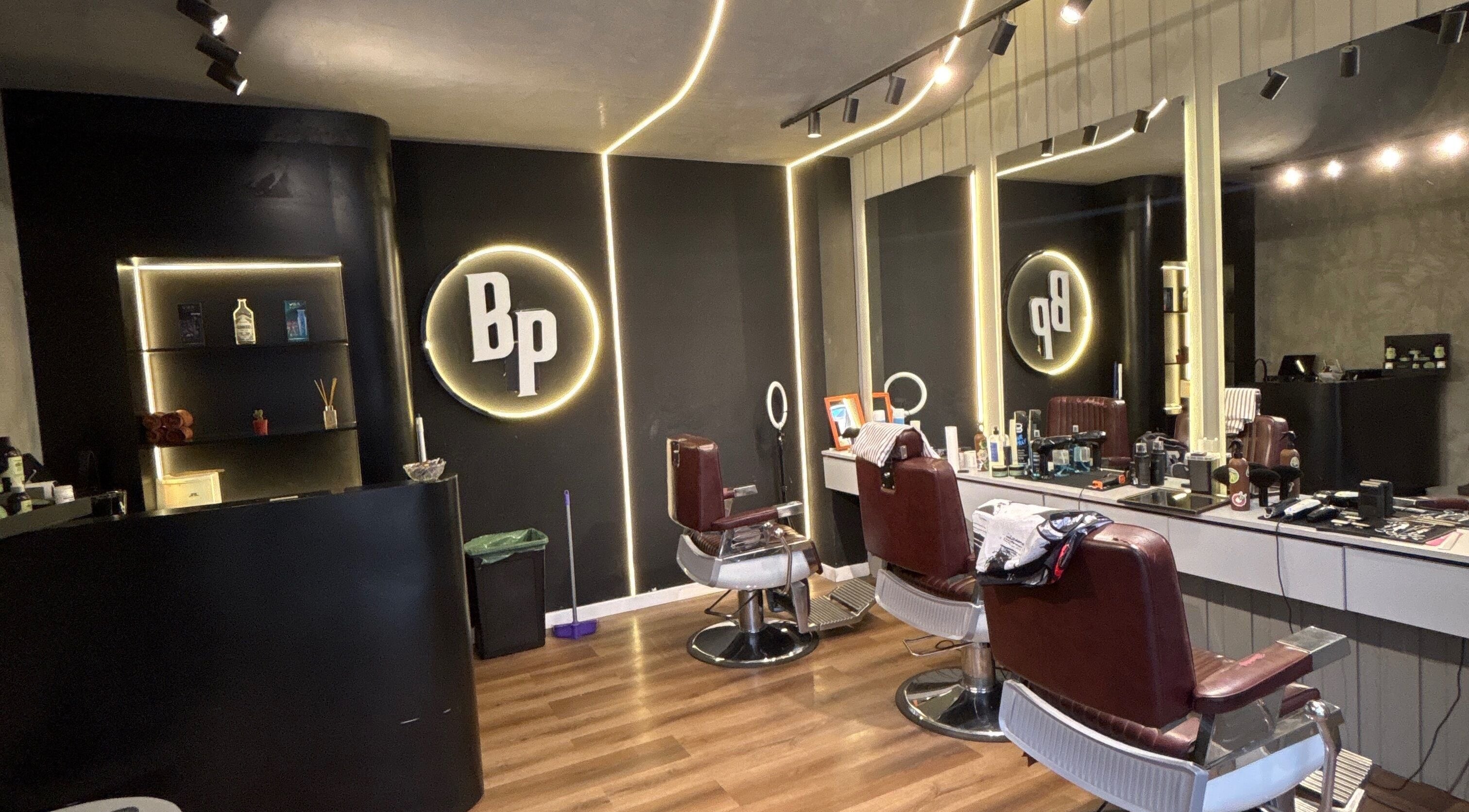 Interior moderno de Barbería Popular en Córdoba, Córdoba, AR, con sillones rojos y amplios espejos.