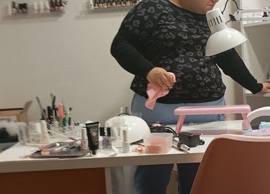 Mesa de trabajo en Nagelstudio Susana, Girona, Cataluña, ES con herramientas de manicura y lámpara UV.