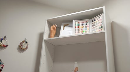 Estante con diseños de uñas en Nagelstudio Susana, Girona, Cataluña, ES, mostrando variedad de colores y estilos.