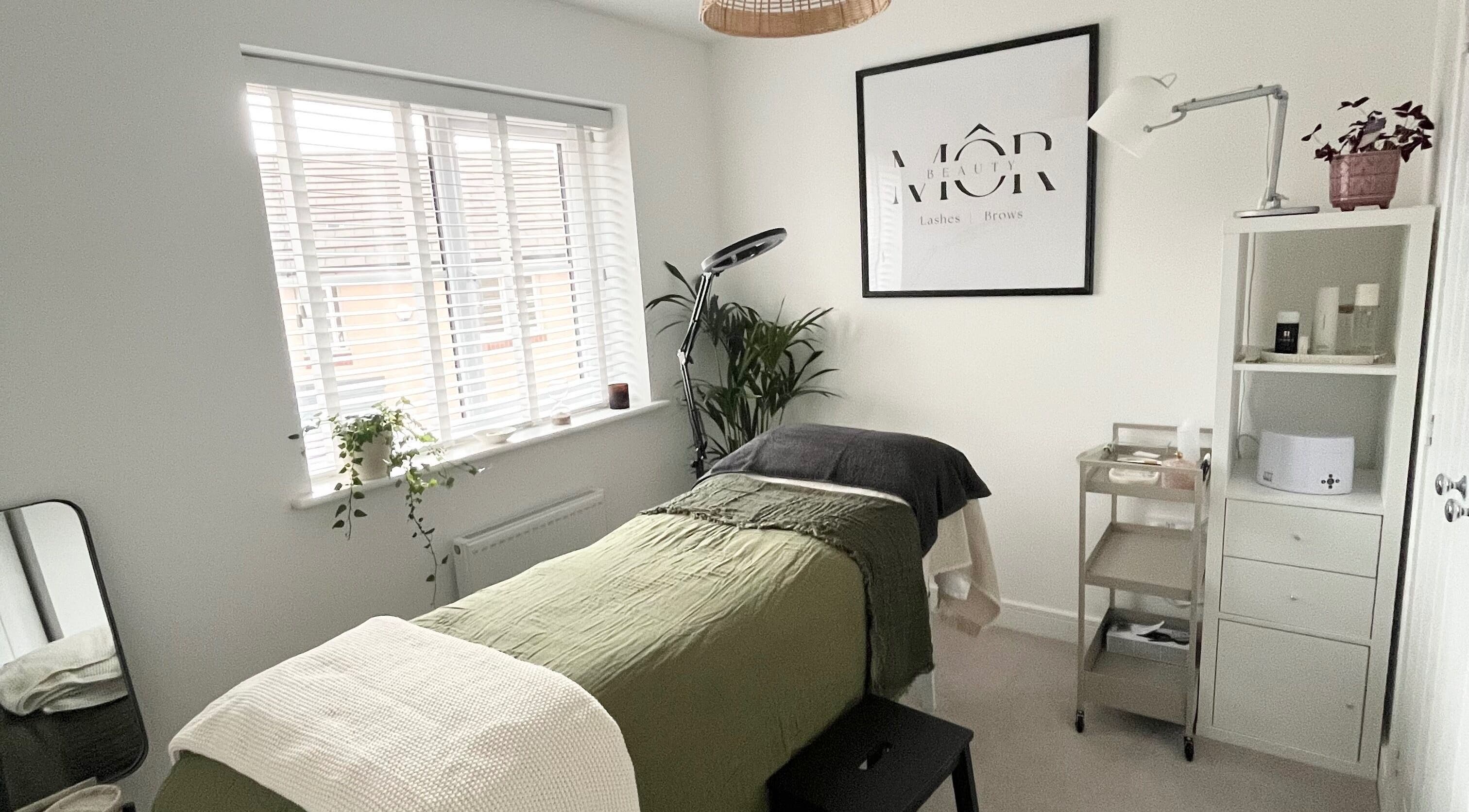 Tranquil beauty room at MÔR Beauty, Rhoose, Wales, GB with lush decor and cozy massage table.