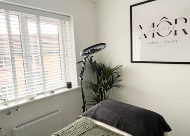 Inviting treatment room at MÔR Beauty, Rhoose, Wales, GB featuring elegant decor and a cozy setup.